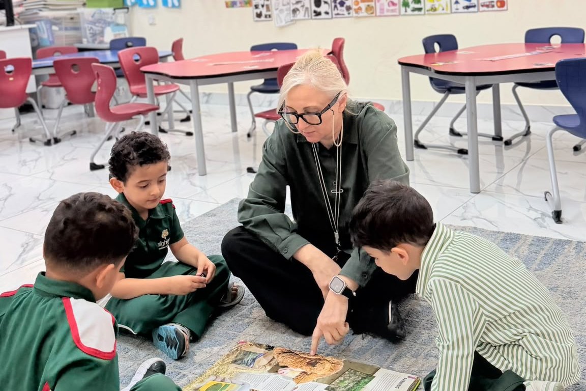 A teacher supporting a group of students at their table